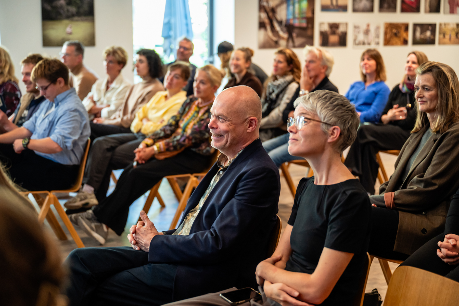 publiek in de zaal zit te kijken naar de interviews